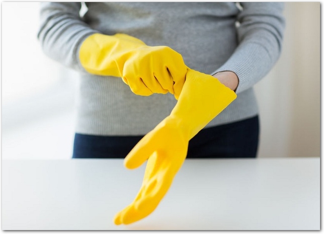 黄色いゴム手袋をはめている女性の手元の様子